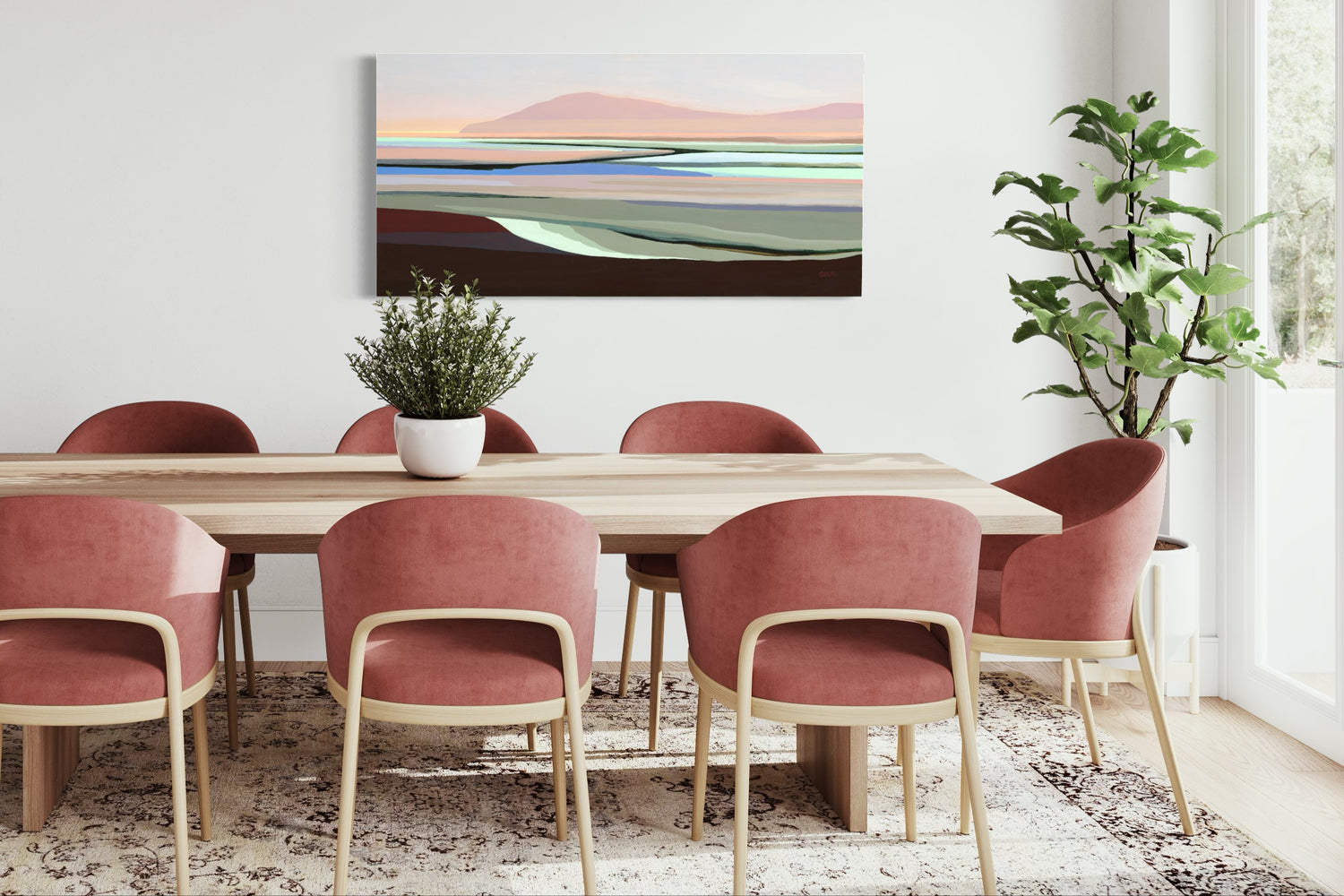 A contemporary and colourful painting by Angela Seear sits above an oak table with modern dusty pink chairs. 